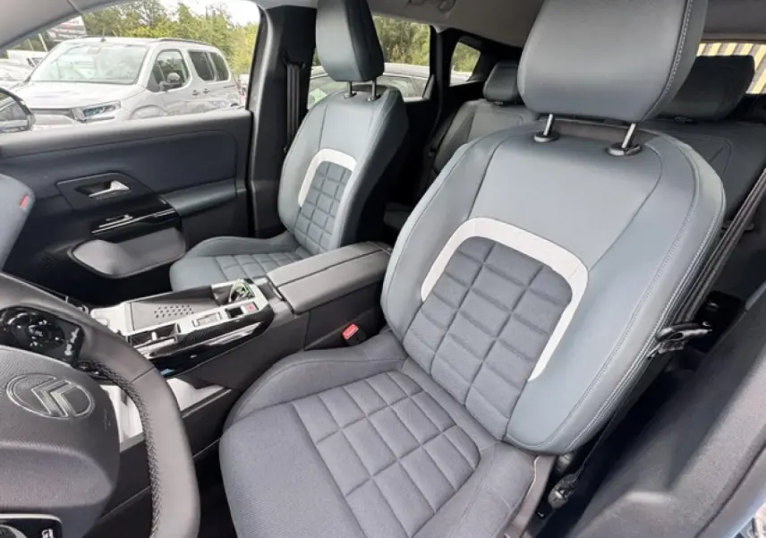 Vue intérieure côté conducteur du Citroën C5 Aircross 2026, sièges gris avec surpiqûres carrées et volant multifonction.