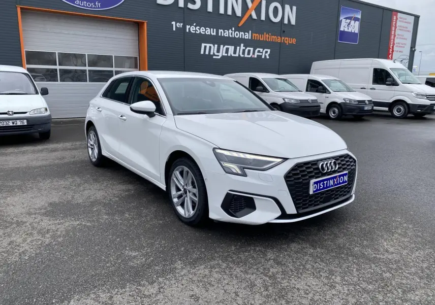 Audi A3 Sportback blanc Ibis vue 3/4 avant droit, avec calandre hexagonale noire et phares LED distinctifs.
