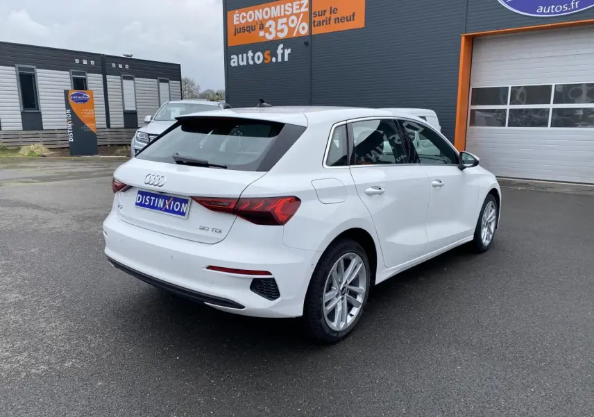 Audi A3 Sportback blanc Ibis vue 3/4 arrière droit, avec feux LED et jantes alliage visibles.