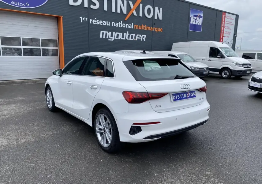 Audi A3 Sportback blanc Ibis vue 3/4 arrière droit, avec feux LED et jantes alliage visibles.