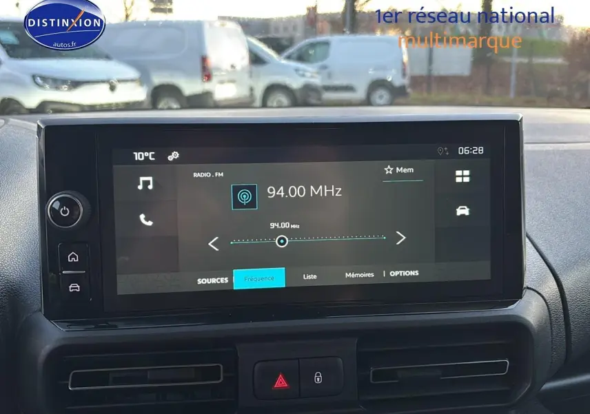 Vue intérieure centrée sur l'écran tactile multimédia du Citroën Berlingo Fourgon blanc, avec commandes et aérateurs visibles.