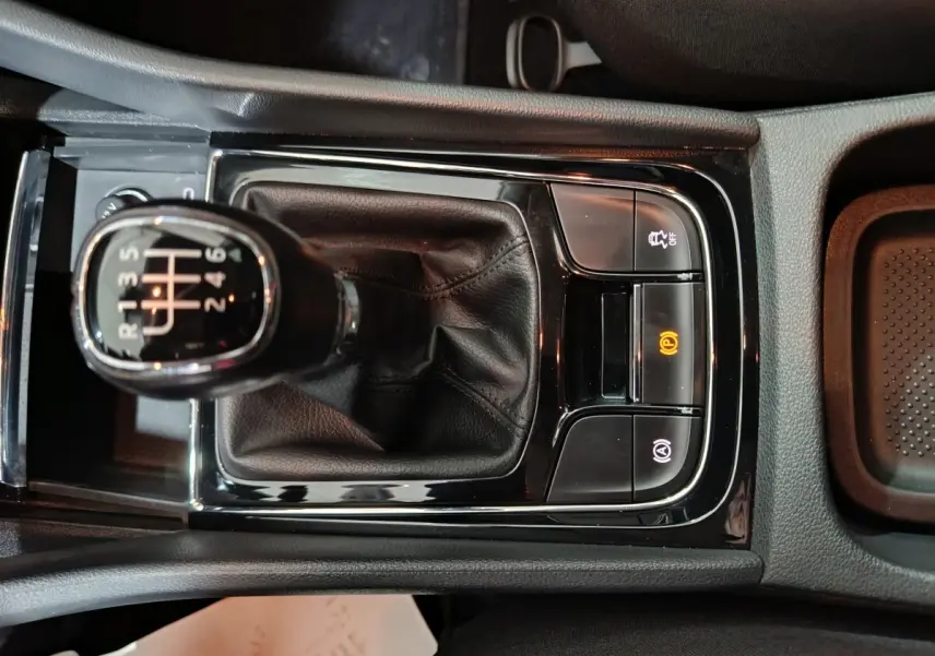 Vue rapprochée du levier de vitesse manuel noir et des commandes électroniques de la console centrale du Skoda Karoq 2024.