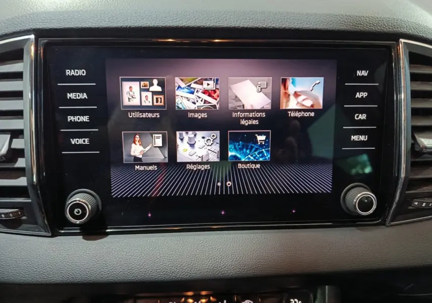 Écran tactile central noir affichant le menu multimédia du Skoda Karoq blanc, vue intérieure frontale.