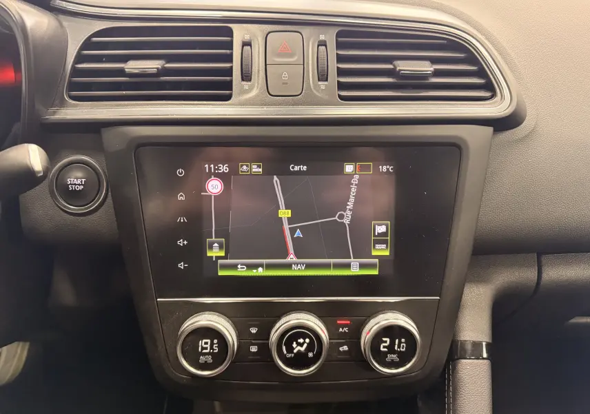 Vue rapprochée du tableau de bord du Renault Kadjar 1.5 dCi 115 Business avec écran tactile de navigation et commandes de climatisation.