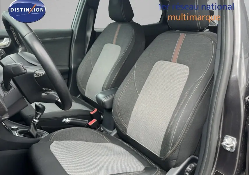 Intérieur du Ford Puma gris 2021, vue côté conducteur montrant les sièges tissu bicolore et la boîte manuelle.
