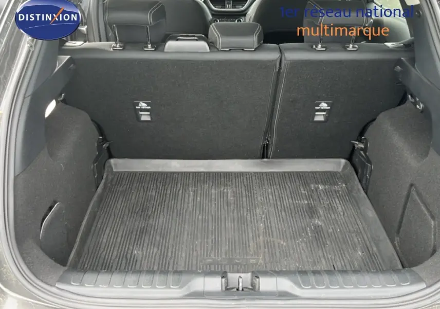 Coffre ouvert d’un Ford Puma gris 2021, vue arrière montrant l’espace de chargement avec tapis en caoutchouc.