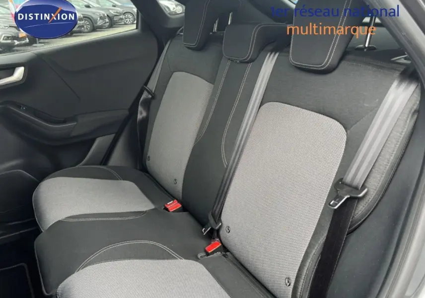 Vue intérieure montrant la banquette arrière en tissu gris clair et foncé du Ford Puma 2021, avec ceintures de sécurité visibles.