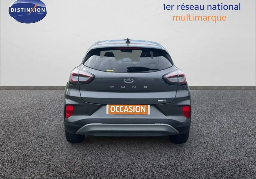 Vue arrière d’un Ford Puma gris 2021 avec feux distinctifs et plaque « OCCASION » sur fond neutre.
