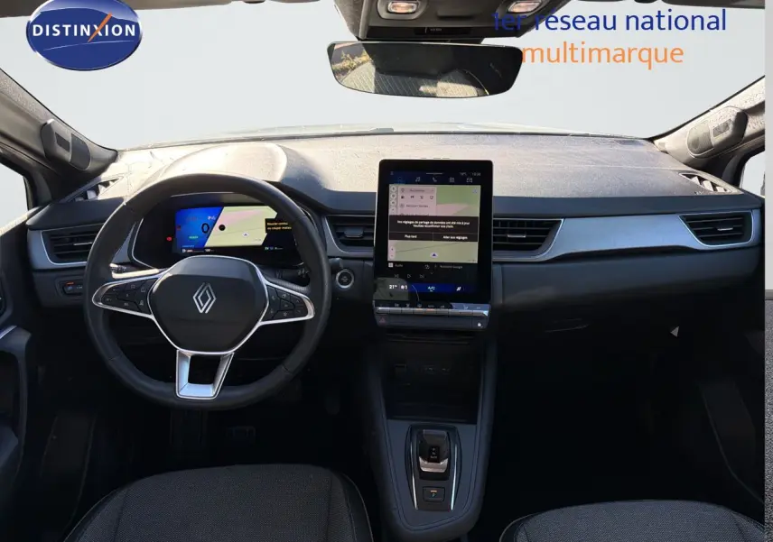 Vue frontale de l’habitacle gris noir du Renault Symbioz E-Tech, avec volant multifonction et écran tactile central vertical.