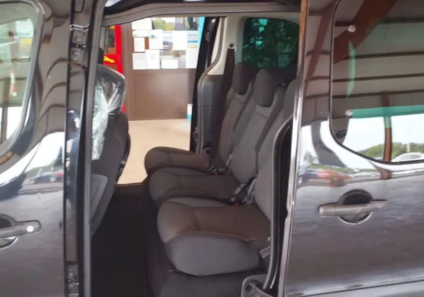 Vue latérale côté droit du Citroën Berlingo noir 2016 avec portes coulissantes ouvertes et sièges arrière visibles.