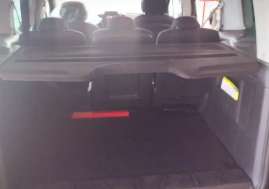 Coffre ouvert d'un Citroën Berlingo noir 2016, vue arrière montrant l'espace de chargement et les sièges arrière.