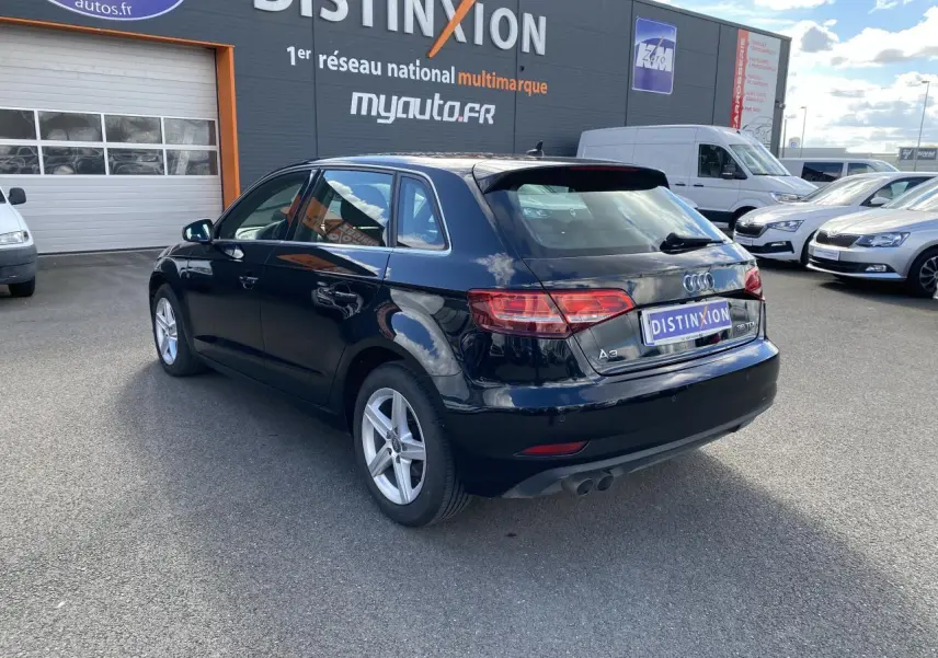 Audi A3 Sportback noir mythic metal vue 3/4 arrière droit, avec feux LED et double sortie d'échappement visible.