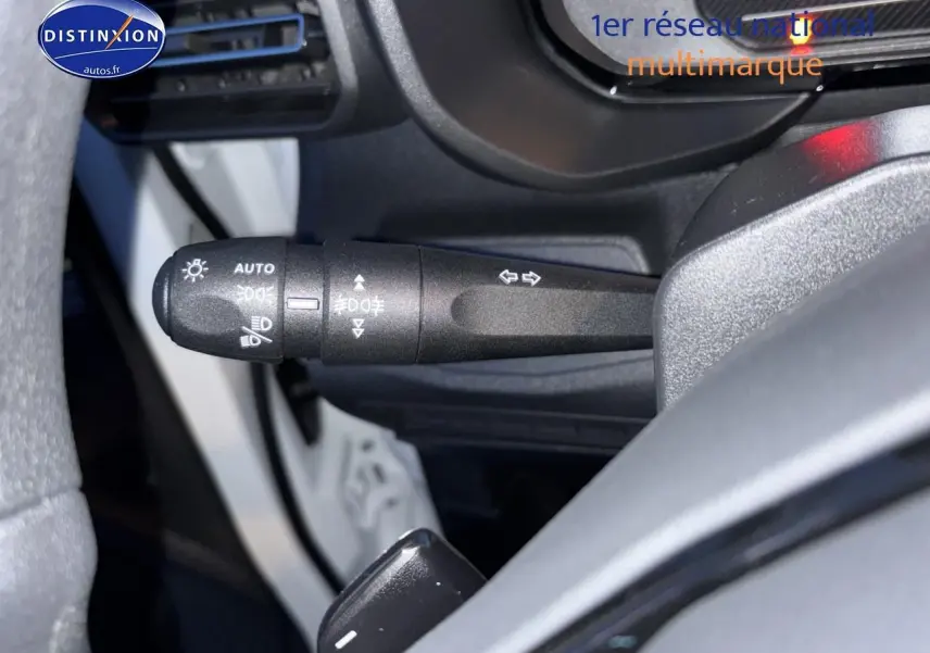 Gros plan sur le commodo des phares et clignotants du Citroën Berlingo Fourgon blanc, intérieur côté gauche.