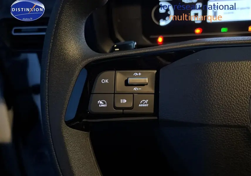 Gros plan sur les commandes gauche du volant multifonction du Citroën Berlingo Fourgon blanc, avec boutons de régulateur et assistances.