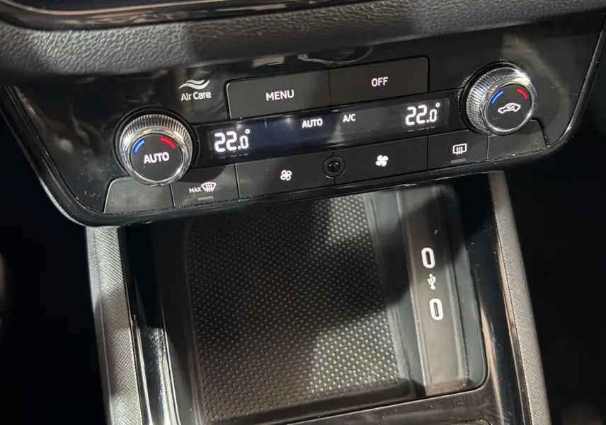 Vue rapprochée de la console centrale noire du Skoda Kamiq 2024 avec commandes climatisation digitale à 22°C.
