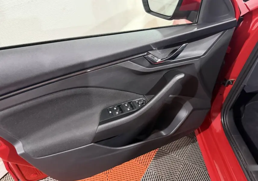Vue intérieure de la porte avant gauche rouge du Skoda Kamiq 2024 avec commandes électriques et poignée noire.