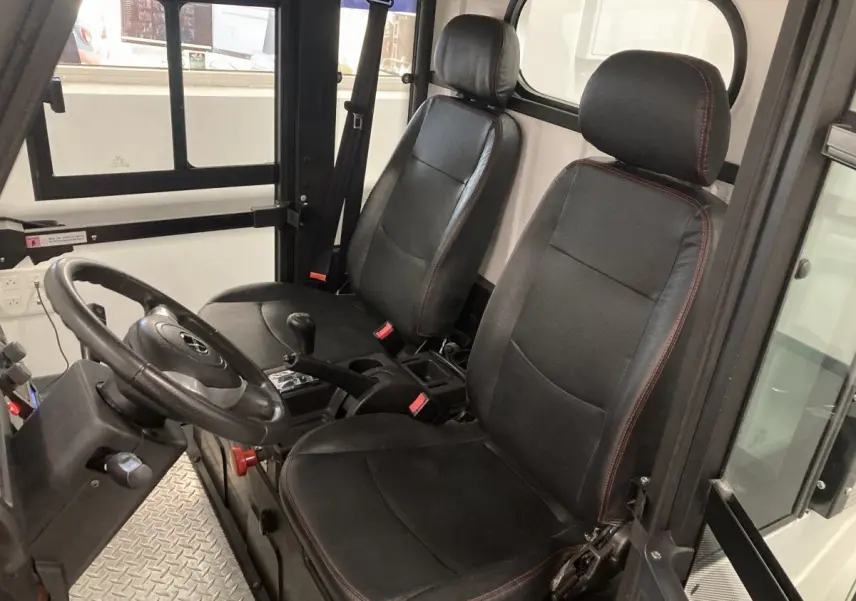 Vue intérieure côté conducteur du Liberty L7E H2 160 blanc, montrant les sièges noirs et le volant 3 branches.