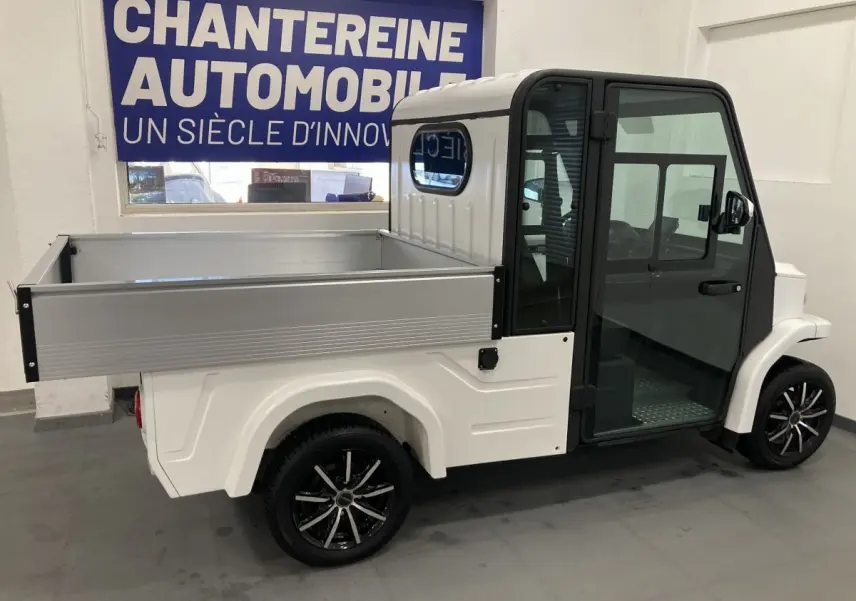Vue de profil droit d’un utilitaire électrique blanc Liberty L7E H2 160 avec kit ridelles et jantes alliage 13 pouces.