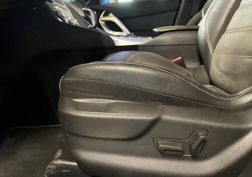 Gros plan sur le siège avant droit en cuir noir du DS5 gris, avec commandes électriques visibles sur la base du siège.
