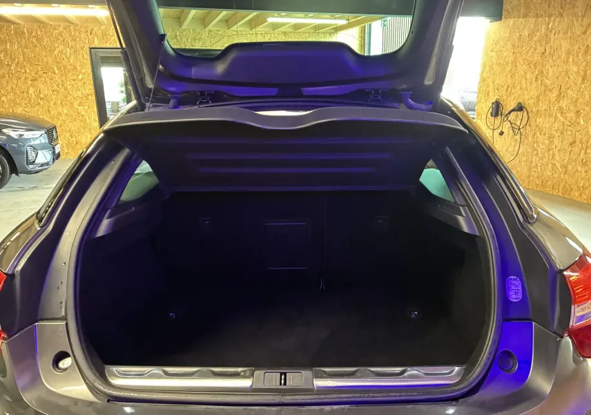 Coffre ouvert vu de l'arrière d'une DS5 gris métallisé, montrant un espace de chargement vide et propre.