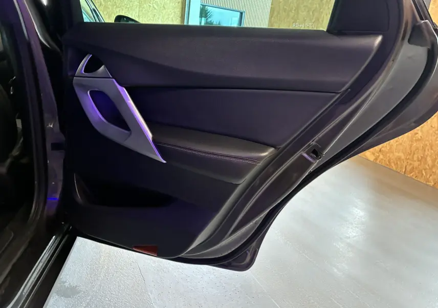 Vue rapprochée de la porte arrière gauche ouverte d’une DS5 gris, montrant le revêtement intérieur noir et la poignée argentée.