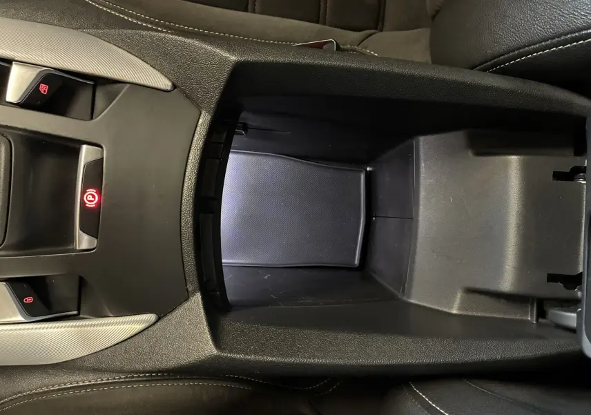 Vue plongeante sur la console centrale noire du DS5 2018, avec frein à main électrique et rangement ouvert.