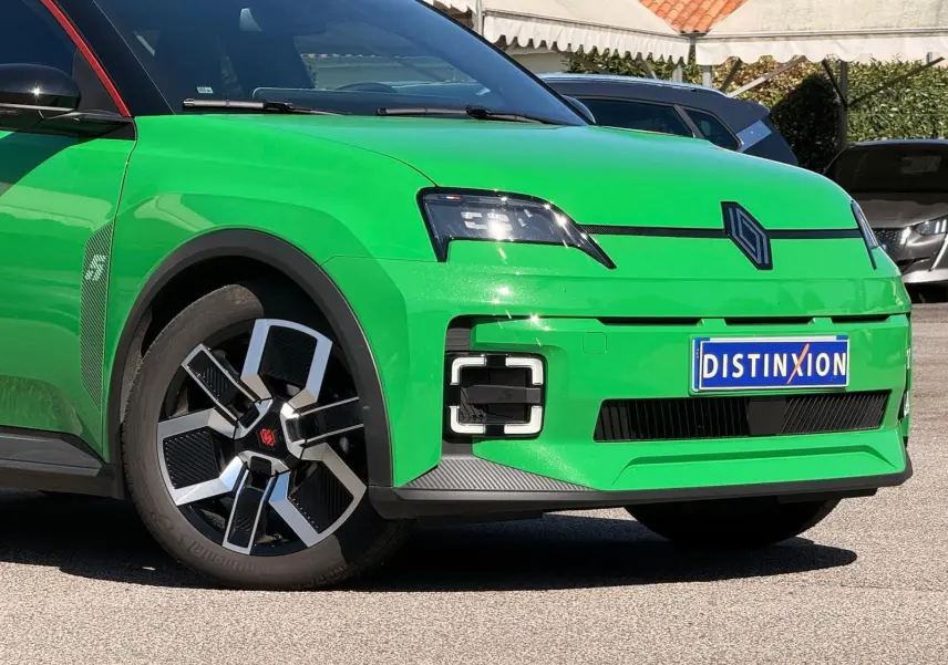 Vue 3/4 avant gauche d'une Renault R5 E-TECH électrique vert Pop avec jantes bi-ton et toit noir étoile.