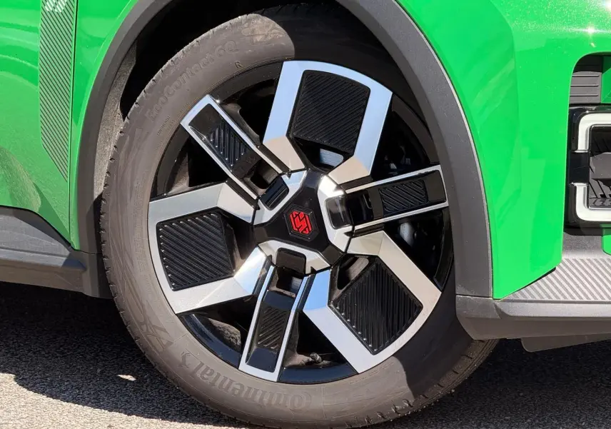 Gros plan sur la roue avant droite de la Renault R5 E-TECH 100% électrique en vert Pop avec jante bi-ton noire et argent.