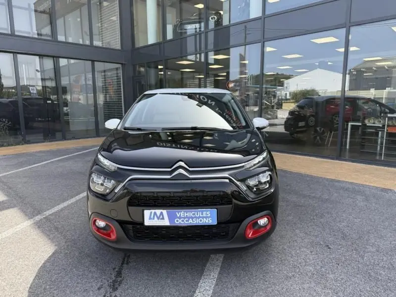 Citroën C3 2021 noir avec toit blanc, vue de face, mettant en valeur les antibrouillards rouges et la calandre distinctive.