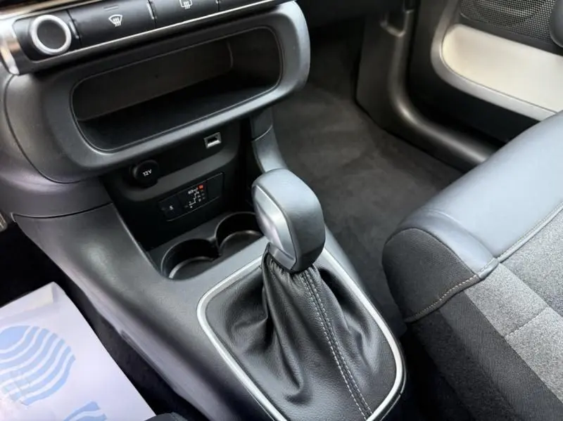 Gros plan sur la console centrale intérieure du Citroën C3 2021 noir avec toit blanc, mettant en valeur le levier de vitesse automatique.