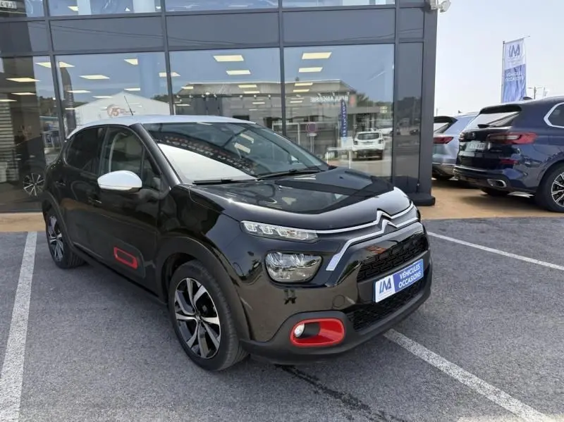 Citroën C3 2021 noir avec toit blanc, vue 3/4 avant droit, détails rouges sur pare-chocs et bas de porte.