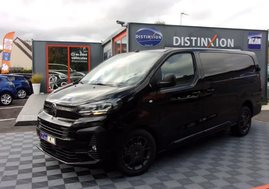 Vue 3/4 avant gauche d'un Citroën Jumpy XL noir Perla avec jantes noires, stationné devant un showroom Distinxion.