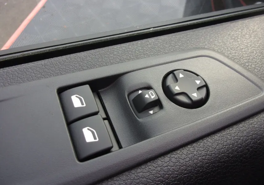 Détail des commandes de réglage des rétroviseurs et des vitres sur la porte côté conducteur du Citroën Jumpy XL noir Perla.
