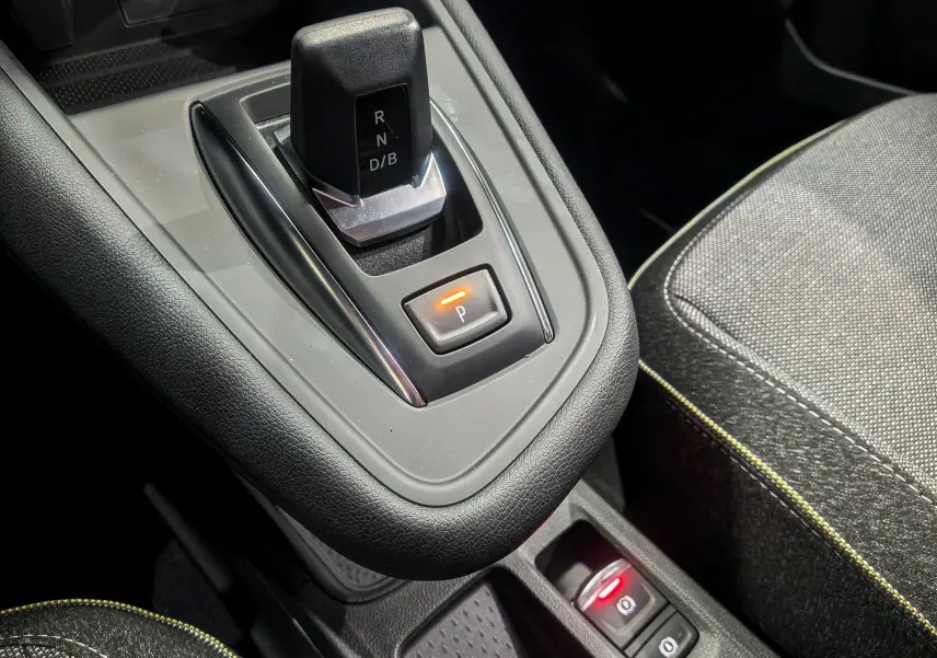 Gros plan sur la console centrale du Renault Symbioz gris Cassiopé, montrant le levier de vitesses automatique et les commandes de frein à main électrique.