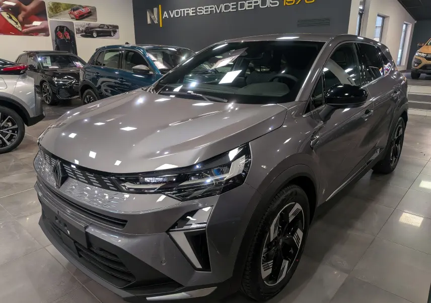 Renault Symbioz E-Tech gris Cassiopé en 3/4 avant droit, avec calandre moderne et jantes biton stylisées.