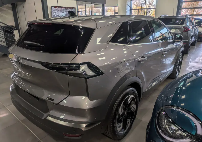 Vue 3/4 arrière droite du Renault SYMBIOZ gris Cassiopé en hybride, soulignant ses feux arrière LED et ses jantes bicolores.