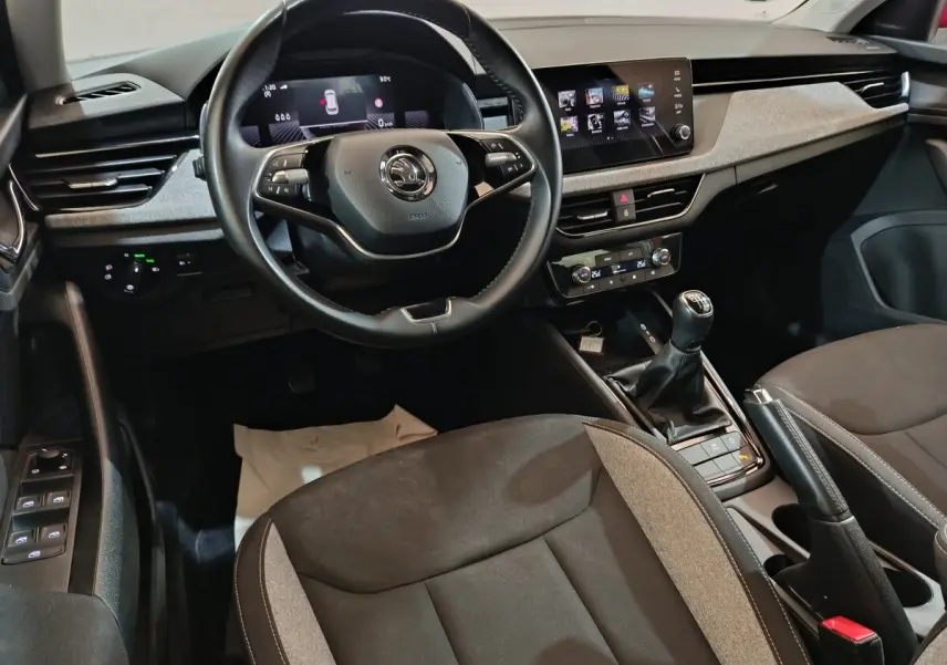 Vue intérieure avant du Skoda Kamiq 2024, volant cuir multifonctions, écran tactile central et levier de vitesses manuel.