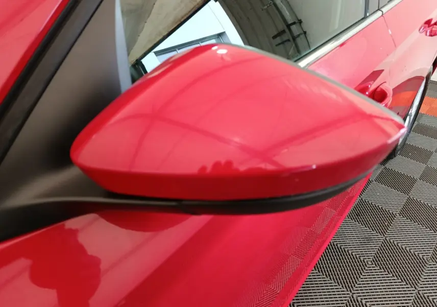 Rétroviseur côté conducteur rouge vif du Skoda Kamiq 2024, vue rapprochée en angle avant gauche.