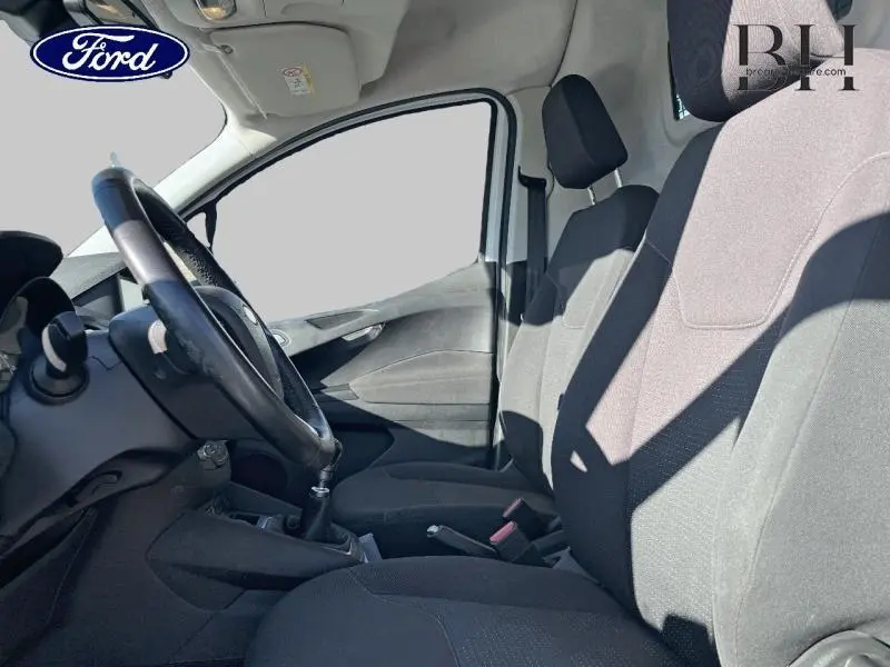 Vue intérieure côté gauche du Ford Transit Courier 2019, sièges tissu noir et volant cuir multifonction.