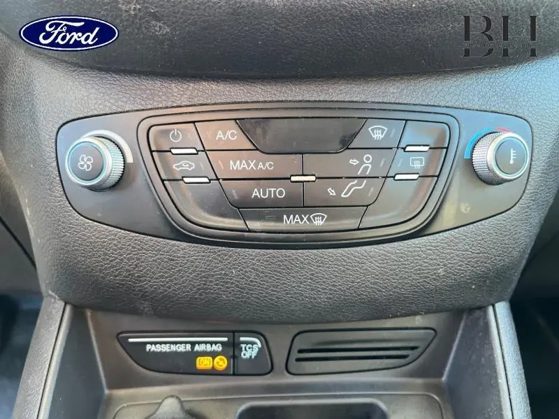 Vue rapprochée du tableau de commande de climatisation du Ford Transit Courier Fourgon blanc Glacier, avec réglages tactiles et boutons rotatifs.