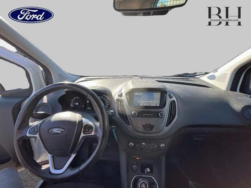 Vue intérieure du tableau de bord et volant cuir multifonction du Ford Transit Courier Fourgon blanc Glacier, écran tactile Sync 3 visible.