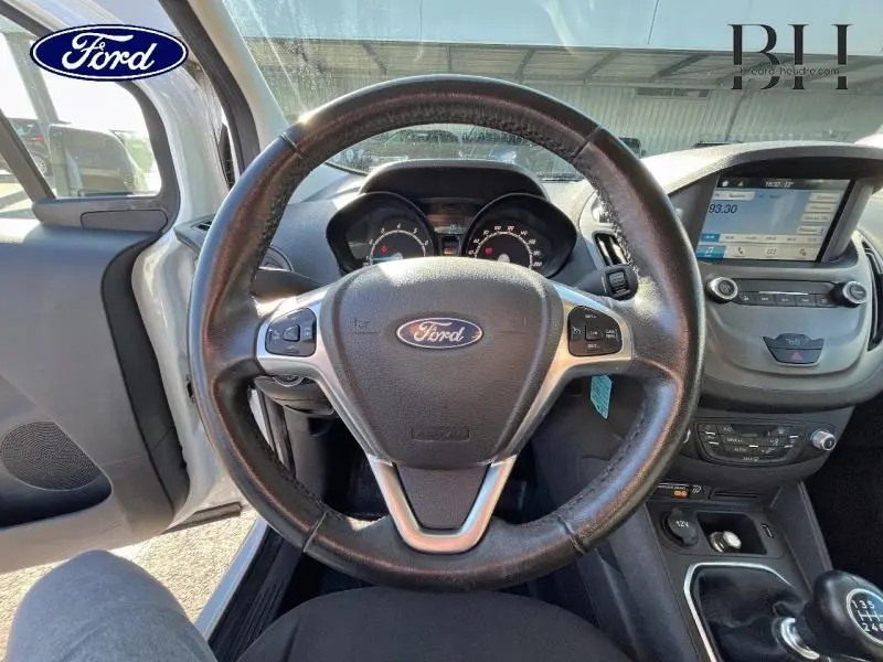 Vue intérieure centrée sur le volant cuir multifonction du Ford Transit Courier blanc Glacier avec tableau de bord et écran tactile.