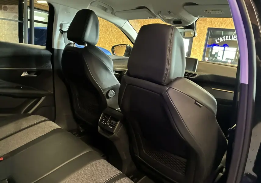Vue intérieure arrière côté gauche du Peugeot 3008 noir 2020, montrant les sièges en tissu et cuir et la console centrale.