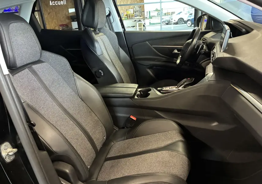 Vue intérieure côté droit du Peugeot 3008 noir, mettant en valeur les sièges tissu et cuir ainsi que le tableau de bord moderne.