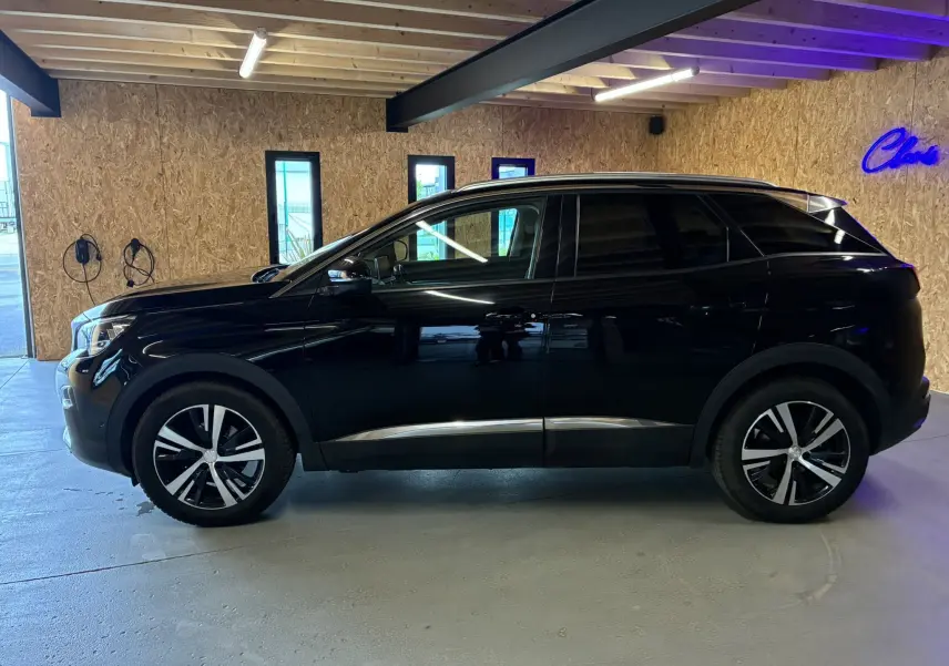 Vue de profil côté gauche d’un Peugeot 3008 noir 2020 dans un garage avec éclairage naturel et néon bleu.