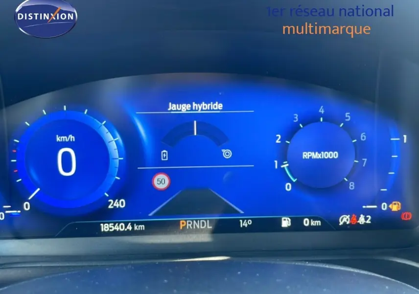 Tableau de bord numérique bleu du Ford Puma 2023, affichant vitesse, compte-tours et jauge hybride.