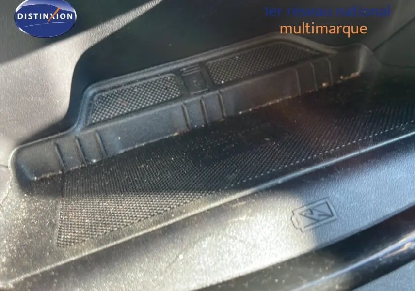 Détail du tapis de sol noir avec logo Ford dans un Ford Puma gris Solar Metal, vue intérieure basse.