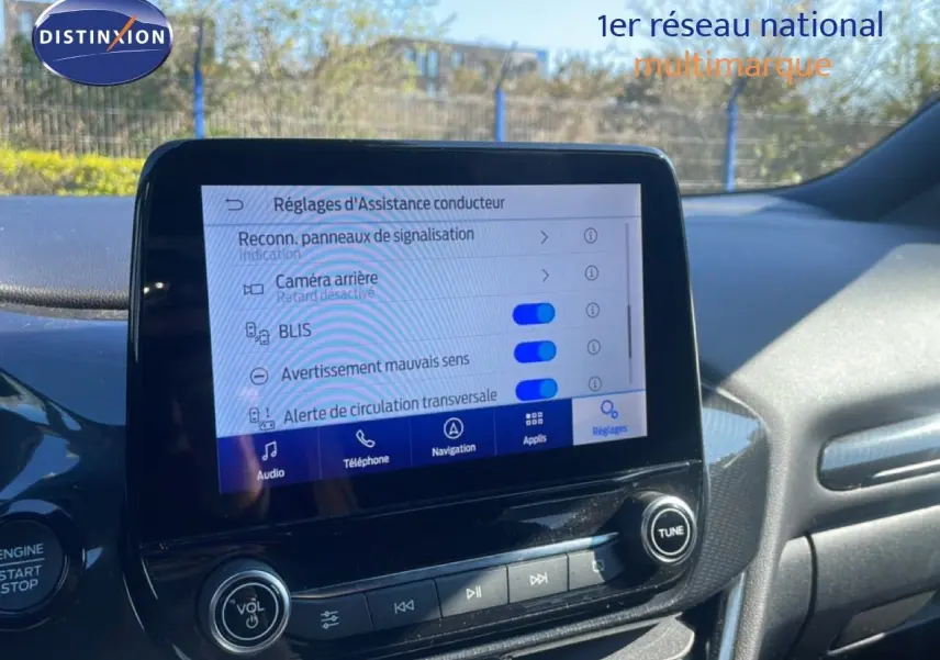 Vue intérieure du tableau de bord du Ford Puma gris Solar Metal 2023, avec écran tactile affichant les réglages d'assistance conducteur.