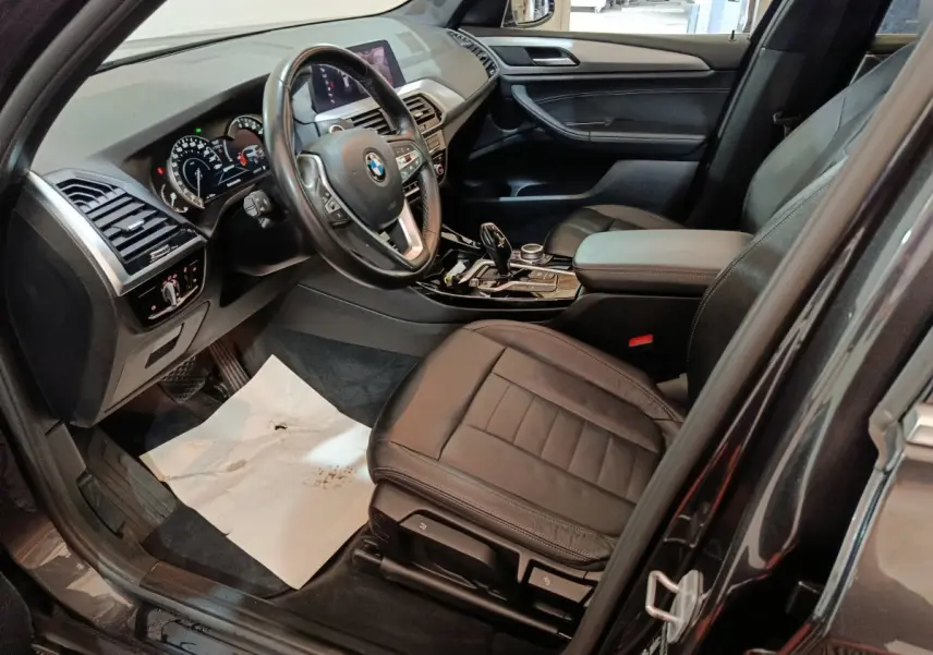 Intérieur côté conducteur BMW X3 gris foncé 2020, vue sur siège cuir, volant multifonctions et console centrale.