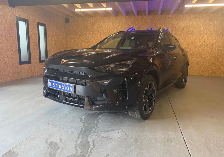 Vue 3/4 avant droite d'un CUPRA Formentor noir 2025 avec jantes alliage et calandre marquée du logo cuivre.